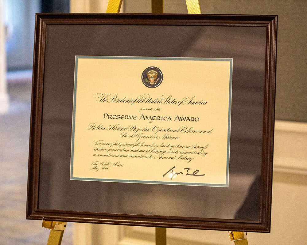 Close up of the Preserve America Award certificate in a brown wooden frame on an easel