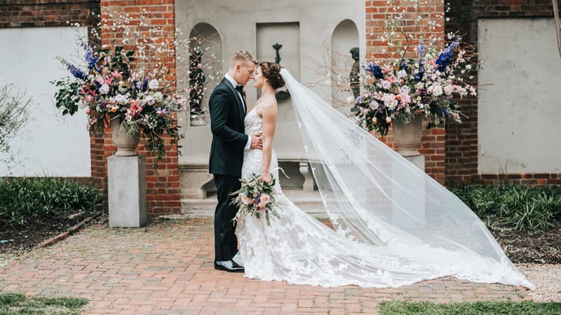 Woman in a bridal gown and man in a tuxedo taking wedding photos at Dumbarton House